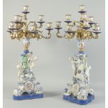 A GOOD PAIR OF SEVRES STYLE EIGHT BRANCH CANDELABRA with cupid support on blue bases. 1ft 11ins