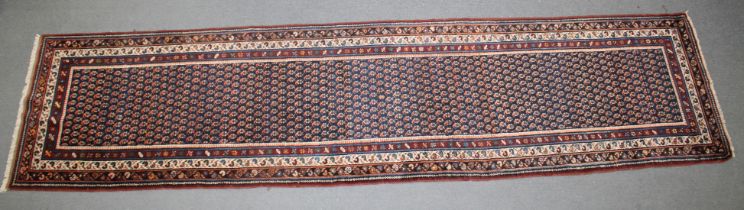A LONG PERSIAN RUNNER RUG rich blue ground with Boteh decoration. 40cm x 108cm.