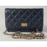 A CHANEL DARK BLUE PADDED CLUTCH BAG. 7.5ins long, 4.5ins high with gilt and leather straps. 24ins