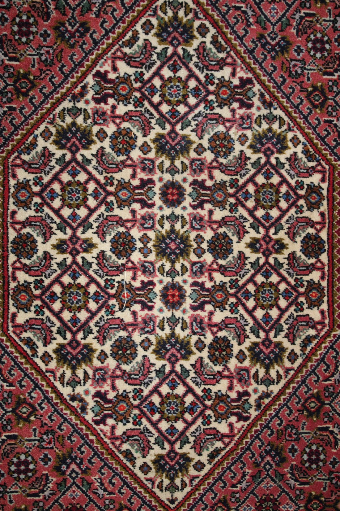 A SMALL PERSIAN RUG with stylised decoration on a rust ground. 106cm x 70cm. - Image 2 of 3