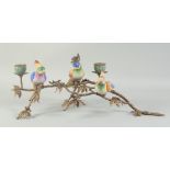 A RUSTIC BRONZE AND PORCELAIN PARAKEET CENTREPIECE with two candle sconces. 1ft 6ins long.
