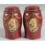 A SMALL PAIR OF RED TOLEWARE TINS AND COVERS. 7ins high.