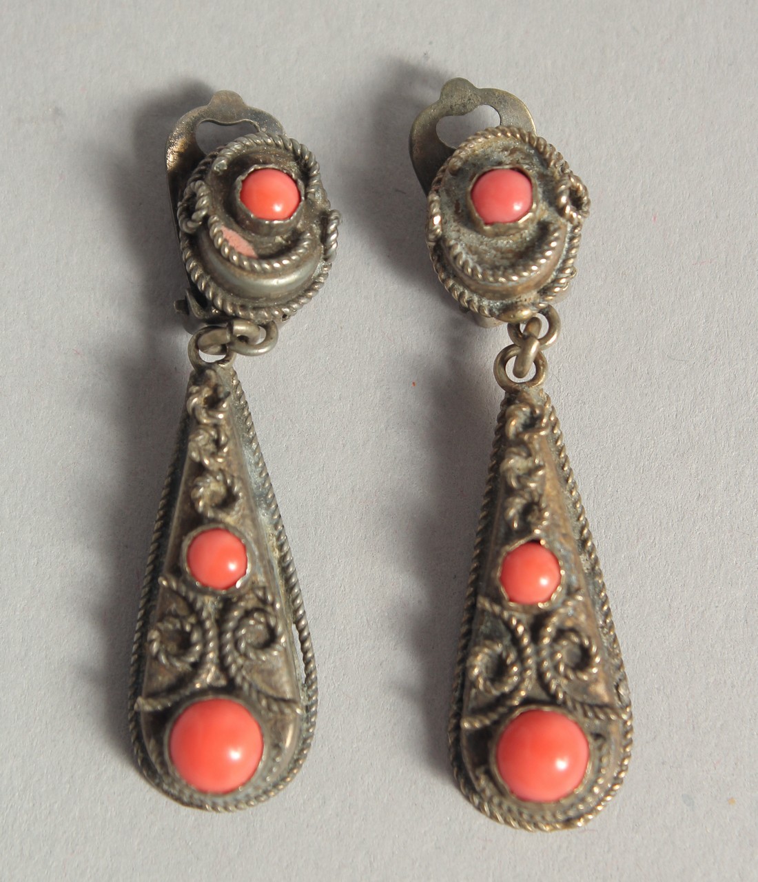 A PAIR OF SILVER AND CORAL EARRINGS.