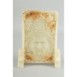A CARVED CHINESE WHITE JADE SCREEN carved with a head. 9ins high.