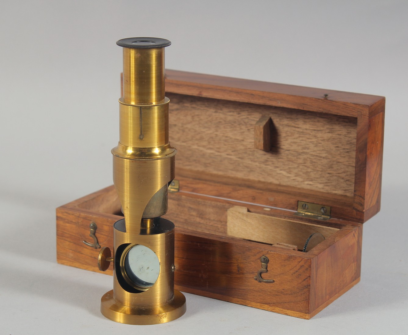 A 19TH CENTURY BOXED DRUM TYPE MICROSCOPE and two slides. 5.5ins long.