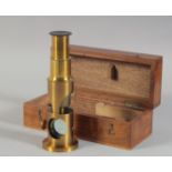 A 19TH CENTURY BOXED DRUM TYPE MICROSCOPE and two slides. 5.5ins long.
