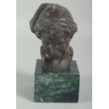 A SMALL BRONZE BUST OF A BOY on a square marble base. 3ins high