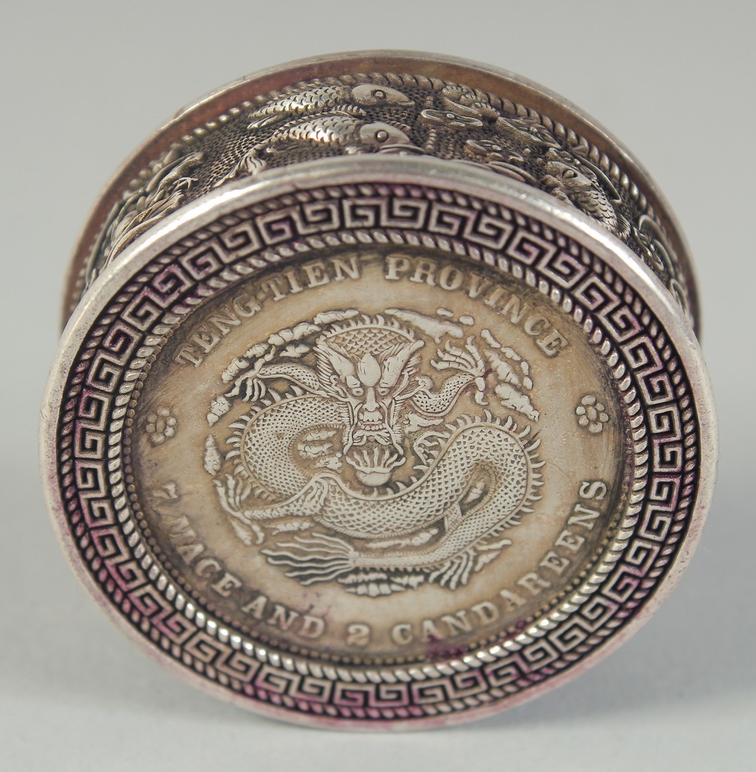 A CHINESE WHITE METAL COIN BOX. 1.75ins diameter.