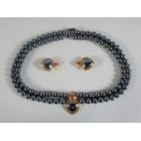 A FOUR ROW HEMATITE BEAD NECKLACE with a 9ct GOLD PENDANT AND MATCHING PAIR OF EARRINGS in