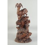 A SUPERB BLACK FOREST CARVING OF A PAIR OF MOUNTAIN GOATS one standing, the other seated on a