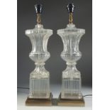 A GOOD PAIR OF GLASS URN SHAPED PEDESTAL LAMPS on a marble base. 23ins high.