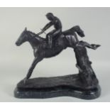 A GOOD BRONZE HORSE AND JOCKEY over the sticks, on a shaped marble base. 13ins long.