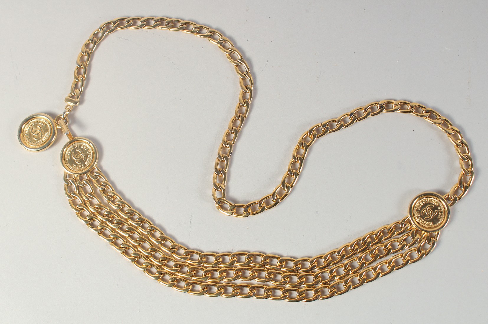 A GOOD LONG CHANEL GILT BELT WITH THREE MEDALLIONS. 5ft long overall.