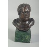 A SMALL BRONZE BUST OF A ROMAN on a square marble base. 3ins high.