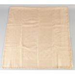 A LOUIS VUITTON CREAM SHAWL with Louis Vuitton emblems. 140cm x 120cm.