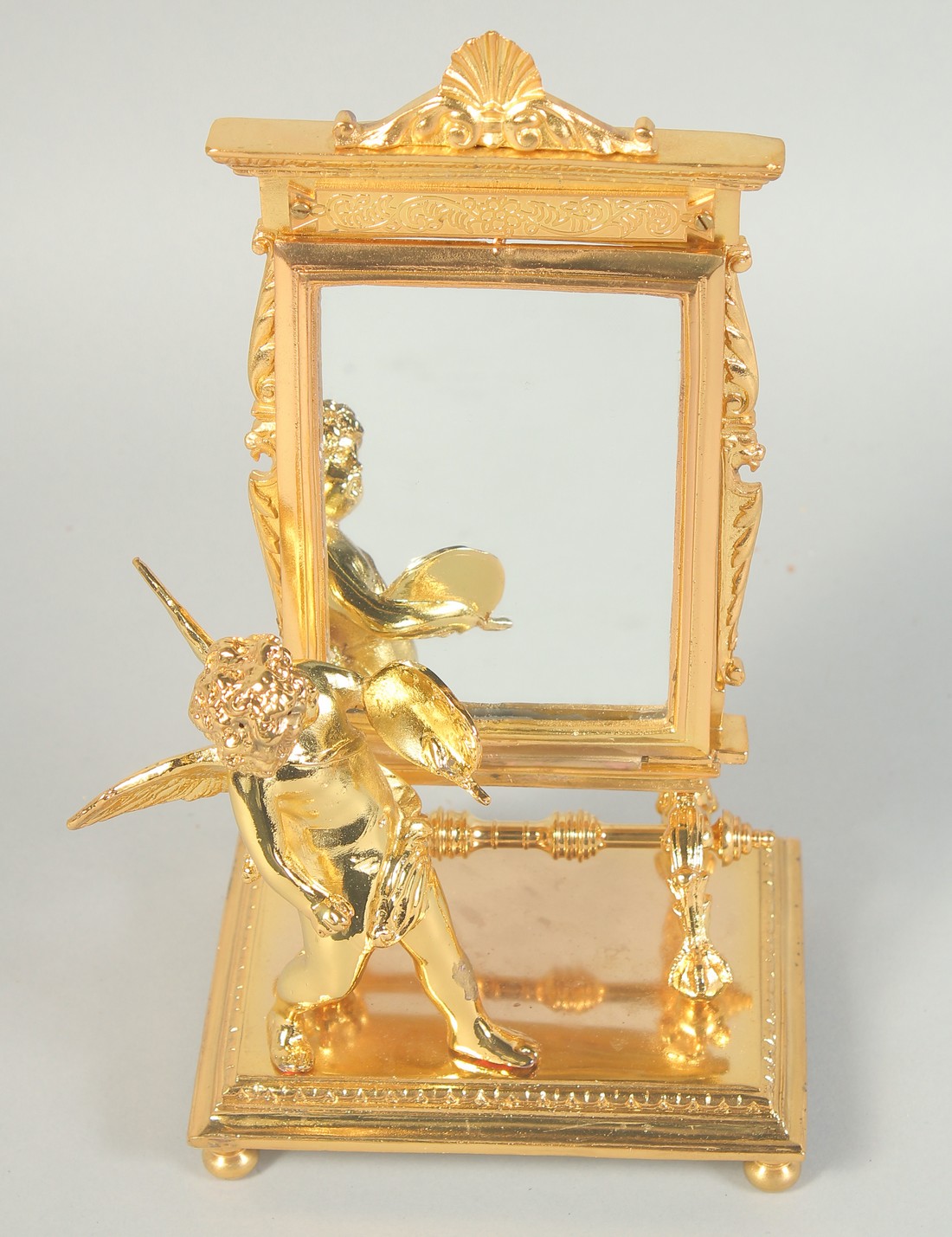 A GILT BRONZE CUPID with a mirror. 8ins high.
