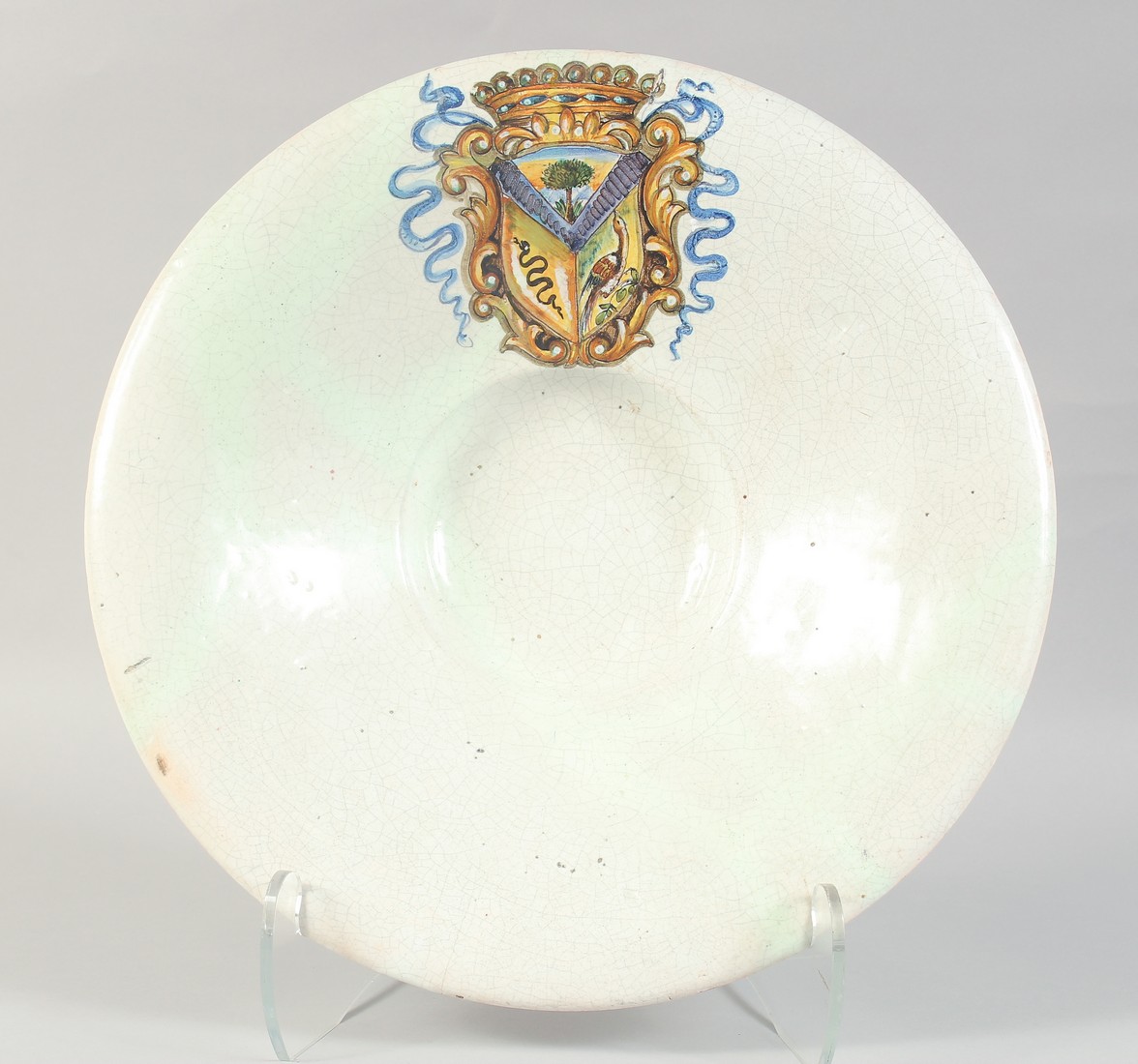 A GOOD 18TH CENTURY POTTERY CIRCULAR ARMORIAL CHARGER with large painted crest. 16ins diameter, 3.