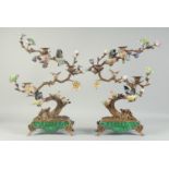 A GOOD PAIR OF BRONZE AND PORCELAIN TREES with scrolling branches, porcelain flower heads and six