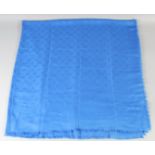 A LOUIS VUITTON BLUE SHAWL with Louis Vuitton emblems. 140cm x 120cm.