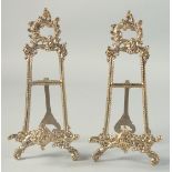 A SMALL PAIR OF BRASS EASELS 9ins high.