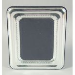 A PLAIN SILVER UPRIGHT PHOTOGRAPH FRAME. Photo size 6.75ins x 5Ins. London hallmark, modern.