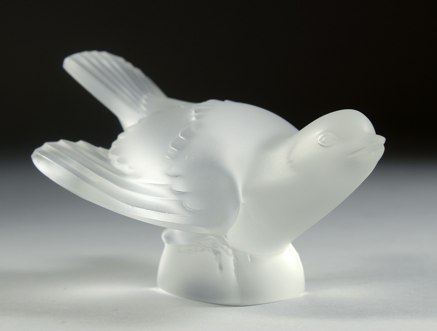 A LALIQUE FROSTED GLASS BIRD, wings closed. Signed, Lalique, France. 5.25ins long.