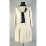 A CHANEL TWO PIECE CREAM SILK LADIES SUIT WITH METAL TRIM. Size 40.