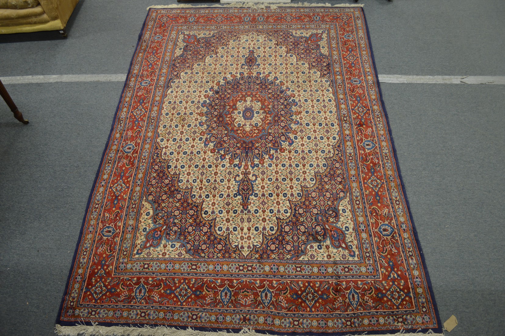 A PERSIAN CARPET, cream ground with floral decoration. 9ft 6ins x 6ft 8ins.