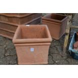 A pair of square shaped terracotta plant pots.