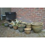 A quantity of glazed plant pots and a barrel shaped tub.