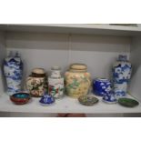 A shelf of Oriental porcelain and cloisonne items.