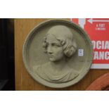 A moulded composite wall plaque modelled with a bust of a young lady.