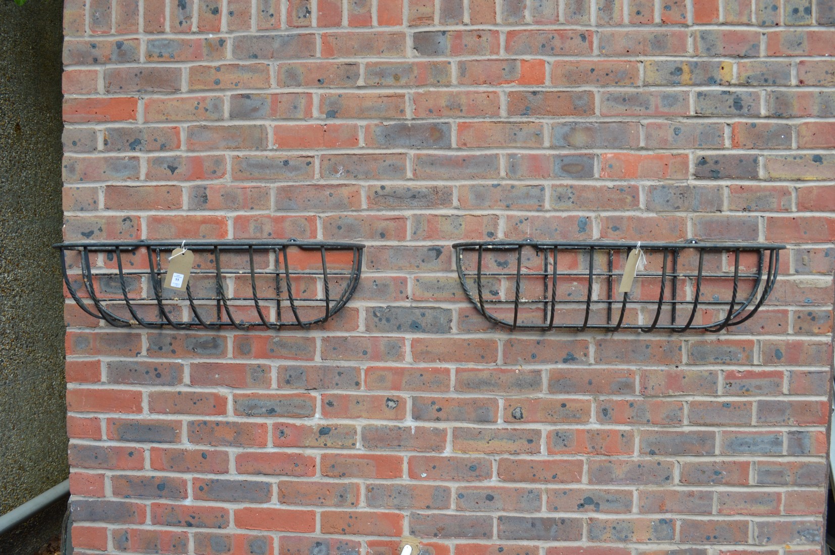 A pair of wrought iron wall planters.