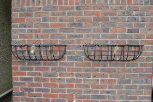 A pair of wrought iron wall planters.
