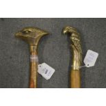 Two walking sticks, the brass handles modelled as birds.
