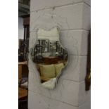 An unusual wall mirror with pierced and shaped glass frame.