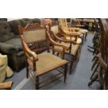 A pair of Victorian walnut framed spindleback open armchairs.