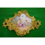 A shaped ormolu framed porcelain tray painted with a young lady and a cherub.