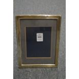 A silver photograph frame with reeded border.