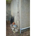 A wrought iron plant spire 243cm high including feet.