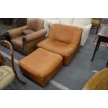 A stylish tan leather upholstered easy chair with matching foot stool.