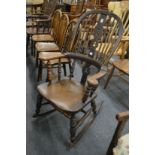 A Victorian beech and elm broad arm rocking chair.