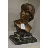 A bronze bust of a young girl on a marble base.