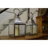 A pair of metal candle lanterns.