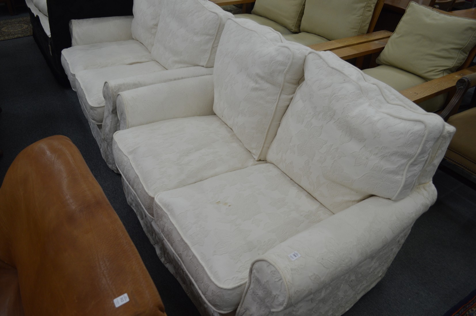 A pair of cream upholstered two seater settees.