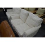 A pair of cream upholstered two seater settees.