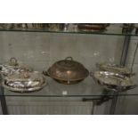 A pair oval silver plated entree dishes and covers, two serving dishes and a food warming dish.