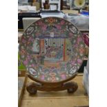 A large Chinese porcelain plate with wooden stand.