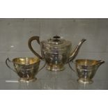 A good silver three piece tea service of oval form with a border of engraved swags and ribbons.