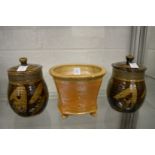 A salt glazed studio pottery jardiniere and a pair of treacle glazed pottery jars and covers.